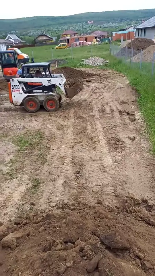 Bobcat rakodó földet terít egy telken